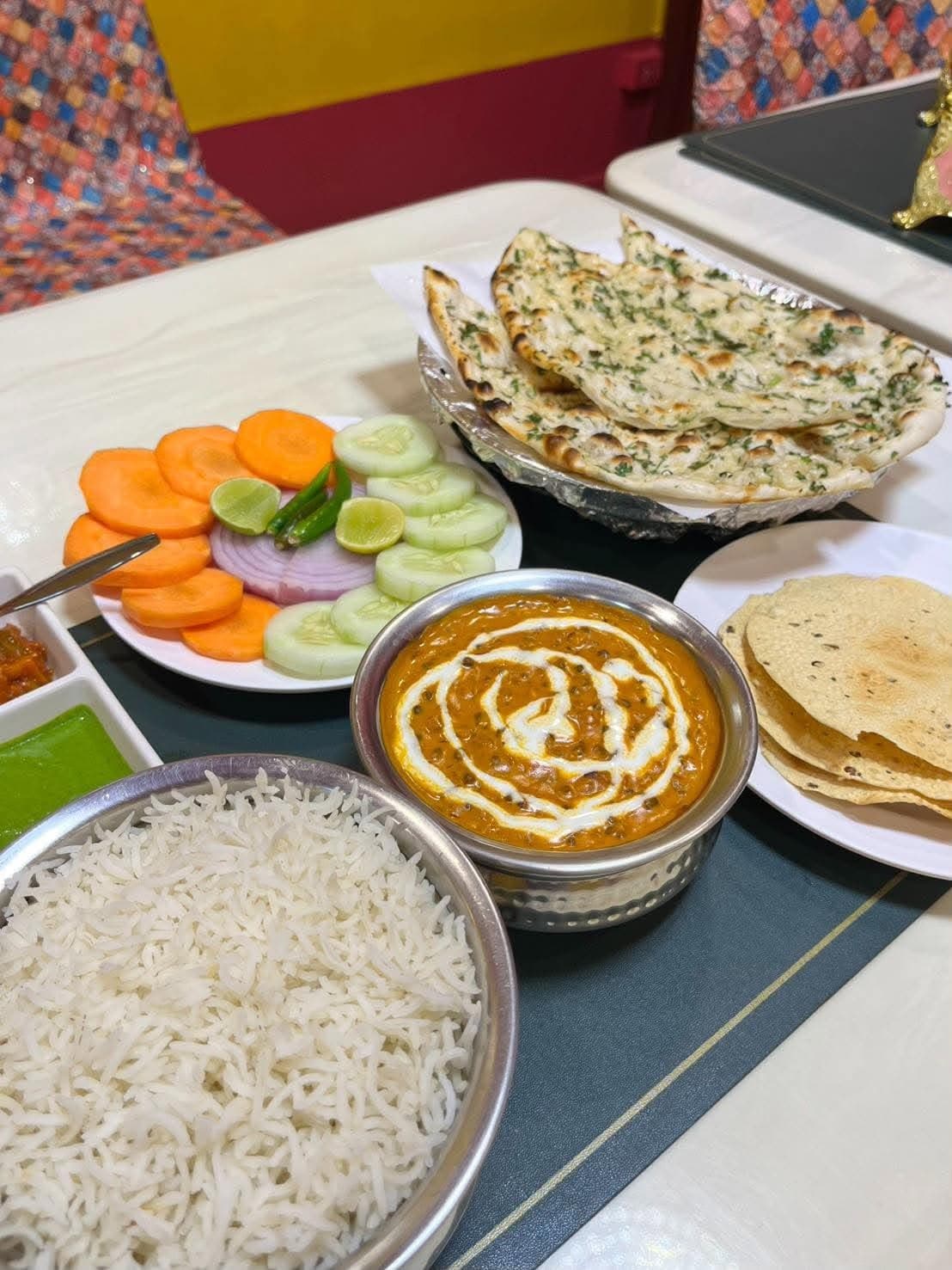 A full Indian spread with dal, rice, naan and salad